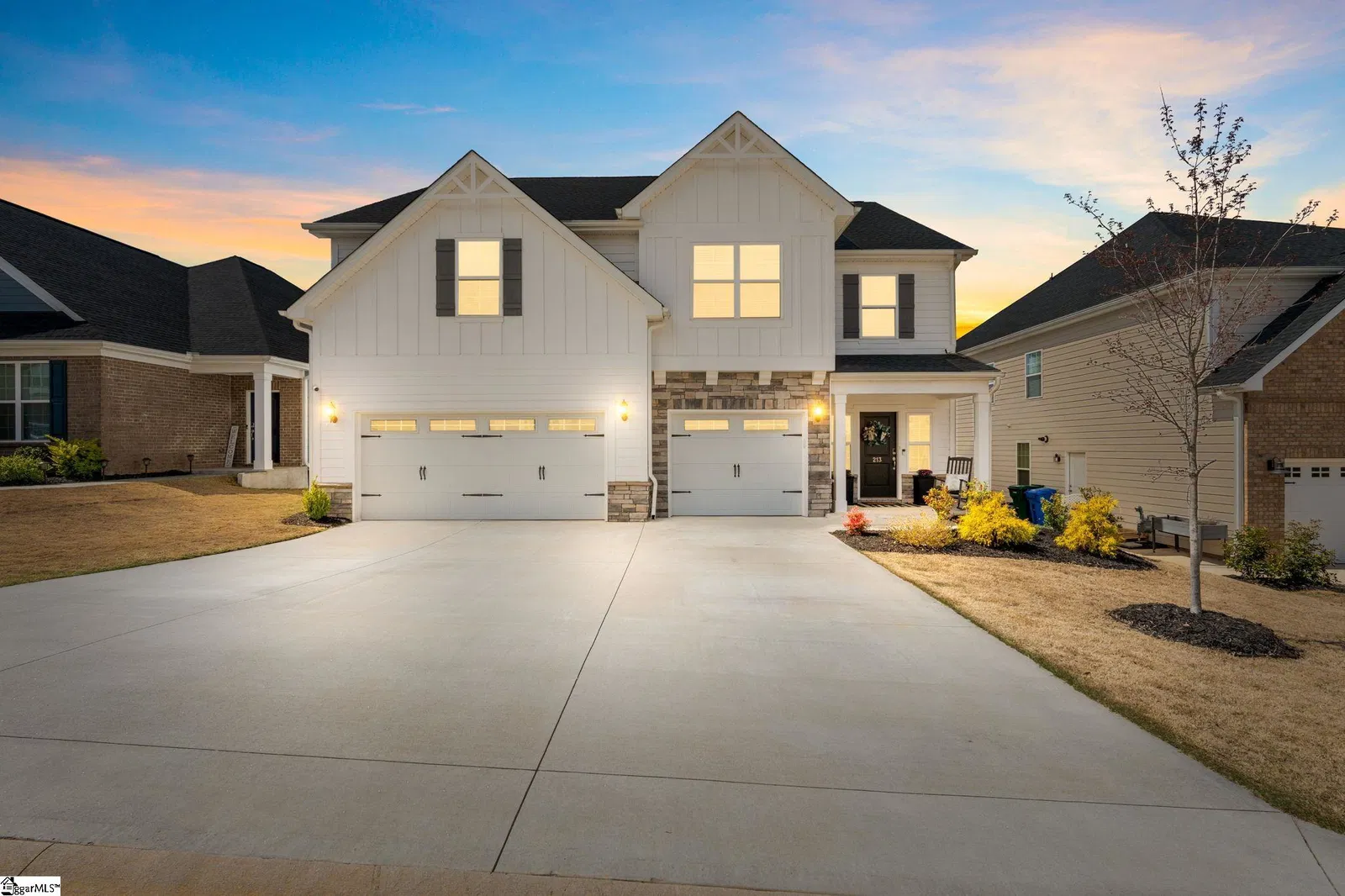 Modern house with illuminated driveway at dusk.