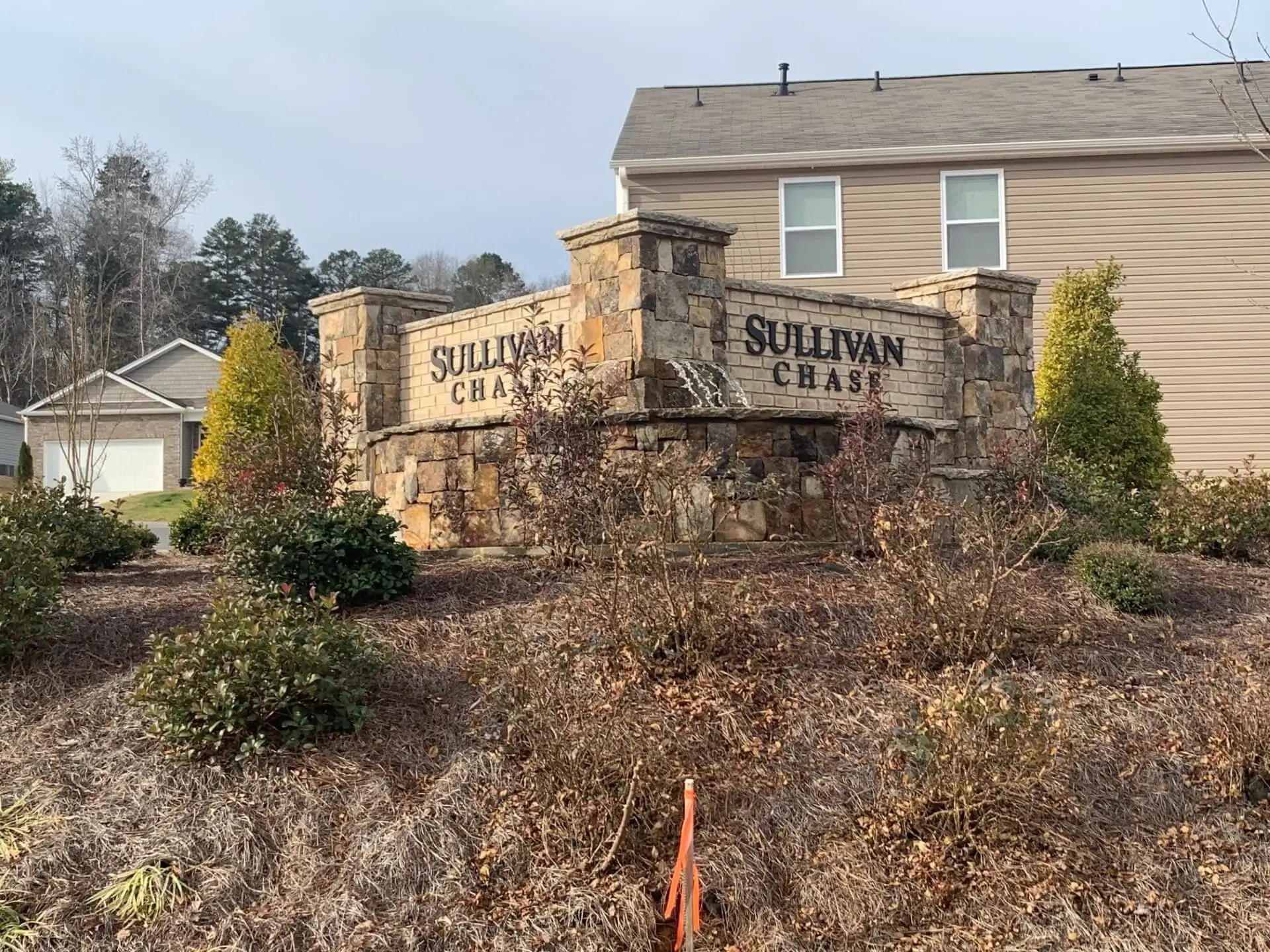 Stone entrance sign reading "Sullivan Chase" houses.